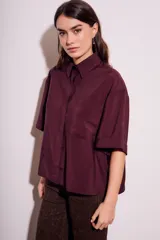 Camisa oversize color borgoña de mangas cortas con puños doblados y bolsillo en el pecho.