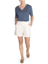 Short de tiro alto confeccionado en lino orgánico, con diseño de cintura cruzada, hebillas laterales ajustables, pinzas frontales y ruedo con dobladillo.