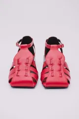 Sandalias de cuero estilo jaula en color rojo, con punta cuadrada, taco cuadrado bajo en color negro y cierre con hebilla ajustable en el tobillo.