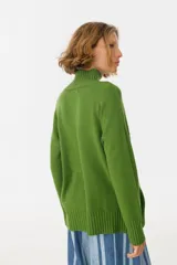 Sweater verde de tejido de punto con cuello alto.
