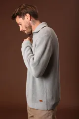 Sweater verde oscuro de punto con cuello alto y cierre de cremallera parcial. Tejido de canalé vertical.