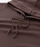 Buzo de pijama con capucha ajustable y cordones, confeccionado en tejido de modal con acabado suave. Presenta mangas largas, puños y ruedo acanalados, ofreciendo un calce holgado y confortable.