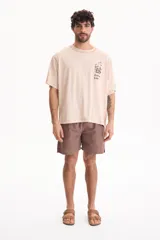 Remera de algodón de manga corta, fit oversize, color beige con estampa en el pecho con diseño de café y texto "Coffee Life".