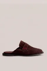 Mocasín destalonado tipo mule de gamuza color beige, con diseño minimalista y detalle de antifaz en el empeine.