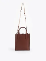 Cartera tipo tote pequeña de cuero color tostado, con doble asa superior y herrajes metálicos plateados en forma de llama en la base de las manijas. Presenta el logo de la marca estampado en la parte inferior frontal.