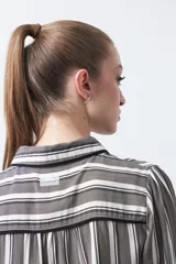 Camisa de manga larga color marrón con estampado de lunares blancos, confeccionada en tejido liviano con cuello clásico y botones frontales.