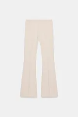 Pantalón de vestir color rosado, tiro bajo, con corte acampanado (flare) y costuras laterales marcadas. Cierre frontal con botón interior y gancho.