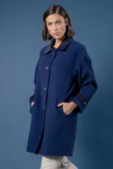 Tapado de corte recto con estampado de pata de gallo en tonos azul y gris. Presenta cuello camisero y detalles en los puños en color negro, cierre frontal con botones y bolsillos laterales.