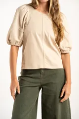 Remera de algodón negro con mangas cortas abullonadas, cuello redondo y costura central frontal.