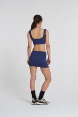 Top deportivo azul con doble escote superpuesto y cintura con elásticos. Confeccionado con textil Activelu con protección UV50+ y nula transparencia.