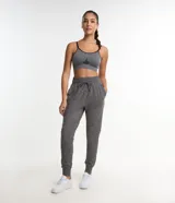 Pantalón deportivo tipo jogger de color gris melange, con cintura elástica ajustable mediante cordón, bolsillos laterales y puños ajustados en los tobillos.
