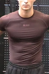 Remera deportiva de compresión con tecnología DryMove, diseñada para absorber el sudor y brindar soporte muscular. Presenta cuello redondo, mangas raglán con costuras planas antifricción y estampado frontal pequeño.