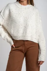 Sweater de punto con diseño jaspeado multicolor, cuello redondo y corte oversize. Presenta mangas largas con puños acanalados y un diseño de tejido acanalado vertical.