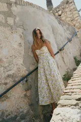 Vestido midi de popelín con estampado floral, escote corazón con volantes y tirantes finos ajustables. Cuenta con bolsillos laterales ocultos, detalle de tablas en el pecho y abertura en la espalda con lazada. Incluye forro interior.