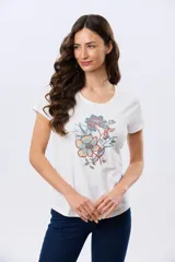 Remera beige de manga corta con cuello redondo, confeccionada en algodón con un diseño delantero que combina estampa floral y detalles bordados.