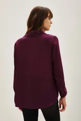 Camisa de viscosa color violeta con cuello clásico, manga larga y cierre frontal con botones. Presenta un diseño bordado con lentejuelas doradas en ambos lados del pecho.
