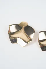 Aros de diseño abstracto con forma orgánica y superficie metálica pulida de acabado espejado.