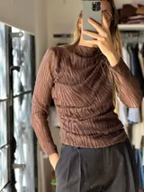 Blusa de manga larga marrón con diseño calado y textura acanalada, cuello alto drapeado y ajuste al cuerpo.