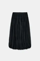Falda midi negra, de tiro alto con cintura elástica y bajo abullonado con elástico interior. El tejido es ligero y con textura plisada o arrugada.
