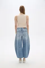 Pantalón de jean celeste con roturas, pinzas y corte barrel.