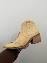 Bota texana de caña baja confeccionada en cuero vacuno con acabado estilo vintage, forrada interiormente en cuero. Presenta punta cuadrada y taco cuadrado de madera.
