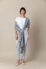 Chal de hilo artesanal color verde con detalles en gris y blanco, con flecos en los extremos y presilla para sujetarlo.