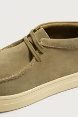 Zapato de cordones de estilo casual, confeccionado en piel con acabado en serraje de color marrón. Presenta detalle de bordón en el empeine, horma redonda y suela de goma a contraste.