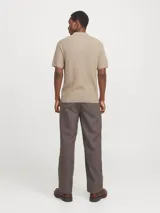 Polo de manga corta confeccionado en tejido de punto estructurado con textura sutil. Presenta cuello polo clásico, cierre frontal con botones y un corte regular.