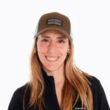 Gorro unisex de 6 paneles, color marrón con malla trasera celeste, visera curva, parche frontal con logo Merrell y ajuste snap trasero.