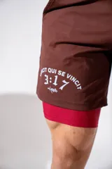 Short deportivo de lycra color marrón, con calza interna integrada en color rojo y estampado lateral en blanco.
