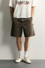 Bermuda relaxed fit color marrón con efecto lavado, cinco bolsillos, bolsillos frontales de carpintero y cierre frontal con cremallera y botón.