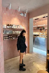 Bota de cuero negro con caña media arrugada, dos correas con hebillas plateadas y taco bajo.