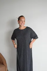 Vestido largo de viscosa color negro con estampado de lunares blancos, escote redondo y mangas cortas.