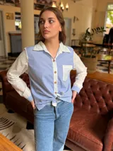 Camisa de corte clásico con diseño combinado, presenta cuerpo a rayas verticales en azul y blanco, con mangas largas y cuello en tela broderie blanca con detalles calados. Incluye bolsillo frontal en broderie y cierre central con botones.