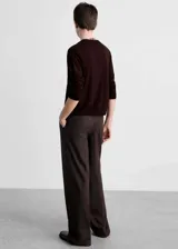 Cardigan de punto color marrón oscuro, con cuello en pico, cierre frontal de botones y diseño de corte recto con mangas largas.