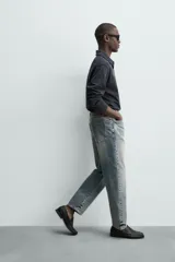 Jeans de corte recto y tiro medio confeccionados en denim de algodón con efecto lavado, diseño de cinco bolsillos y cierre frontal con cremallera y botón.