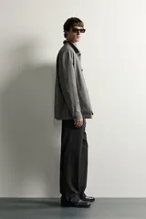 Sobrecamisa gris de corte regular fit con textura, cuello solapa, cierre frontal de botones, bolsillos de parche en el pecho y los laterales, y mangas largas con puños abotonados.