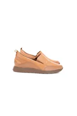Zapato slip-on de cuero vacuno color caramelo con textura delicada, inserciones elásticas laterales y suela flexible.