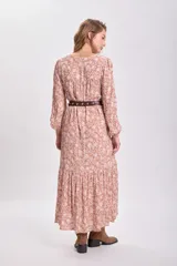 Vestido largo color tostado con estampado floral blanco, corte holgado, mangas largas abullonadas y cinturón marrón.