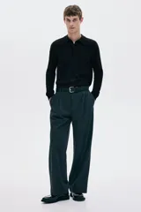 Remera polo de manga larga en punto fino negro, con cuello clásico y tapeta de tres botones. Presenta remates acanalados en puños y bajo.