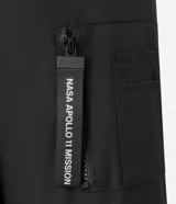 Campera tipo bomber color negro, con cierre frontal, cuello, puños y ruedo acanalados. Presenta parches bordados en el pecho con la bandera de Estados Unidos y el logo de la NASA, además de un bolsillo utilitario con cierre en la manga izquierda.