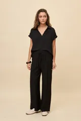 Pantalón gris de corte amplio y silueta fluida, con cintura elástica y cordón ajustable.