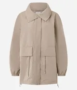 Campera cortaviento oversized color beige, de cuello alto, mangas largas con puños elásticos, bolsillos frontales con solapa y cordón ajustable en la cintura.