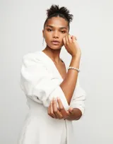 Pulsera con cuentas peque
nas de aleaci
f3n de metales ba
f1adas en plata de ley, con cierre de cuero marr3n.