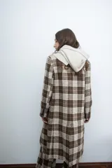 Chaqueta de corte sastre con estampado de cuadros en tonos marrones y beige, con solapas clásicas y cierre frontal con botones.