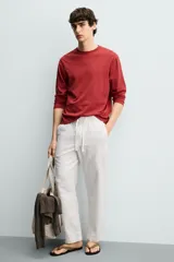 Pantalón de corte regular fit confeccionado en tejido mezcla de algodón, con cintura elástica ajustable mediante cordón, bolsillos laterales y bolsillos traseros de vivo.