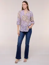 Blusa de gasa estampada de la marca Zac & Rachel, en tonos violeta y marrón. Presenta cuello a la base con escote en V y botones frontales, detalles de plisado en la delantera y mangas largas con sistema para regular su largo mediante presilla y botón.