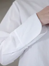 Camisa negra de algodón con cuello con lazo desmontable y mangas largas.