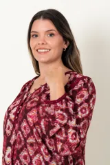 Blusa estampada color borgoña con diseño de rombos, de manga larga y escote en V con aplique de galón.