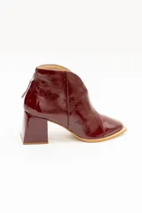 Botinetas de cuero charolado color negro, con taco cuadrado de 6,5 cm, punta cuadrada y diseño de corte en V en el empeine.